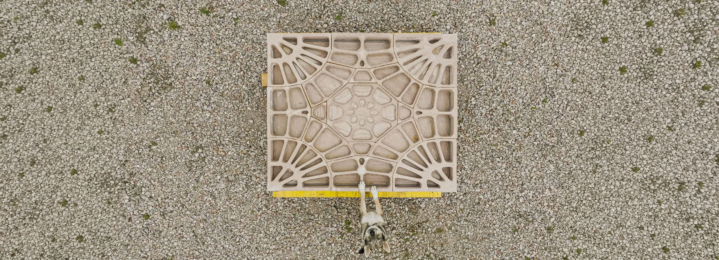 Top view of a square printed floor segment with radiating ribs on gravel