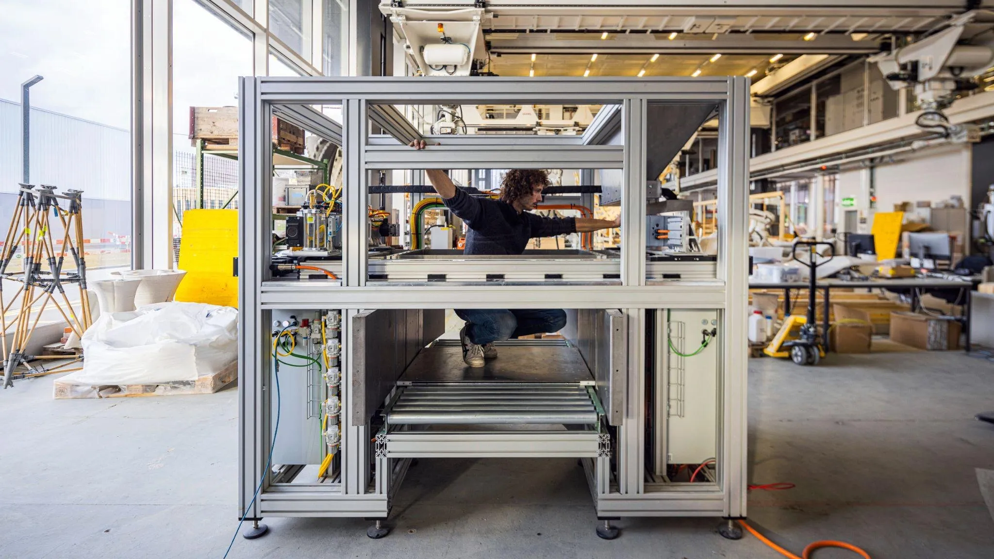 An engineer working inside the frame of the stone printer